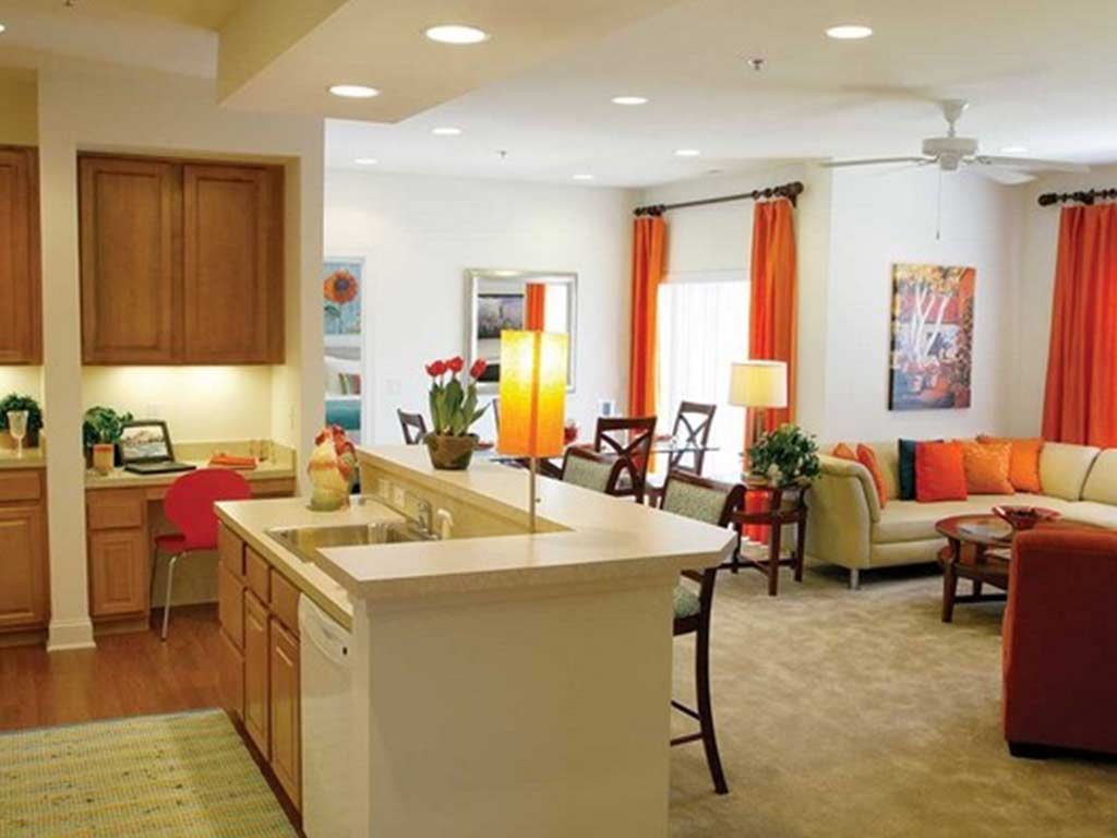 Fully furnished kitchen area with island bar connecting to the dining and living room area.
