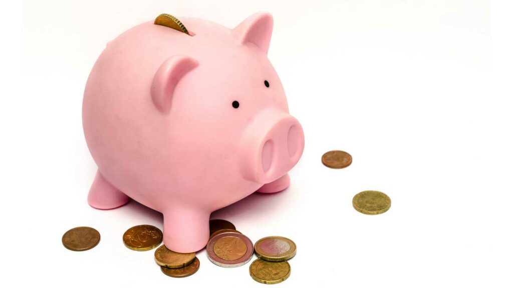 Piggy bank on white background with coins around it